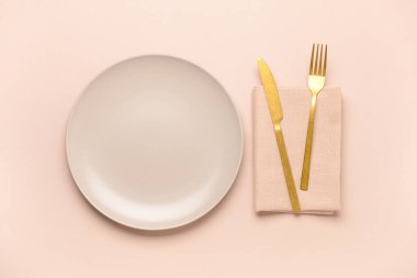 Pembe arka planda temiz tabak ve çatal bıçak takımı