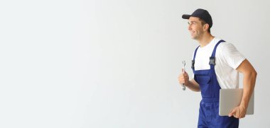 Diz üstü bilgisayarı açık arkaplan ve metin için yeri olan erkek araba tamircisi