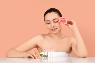 Pembe arka planda gül ve ampulleri olan güzel genç bir kadın.