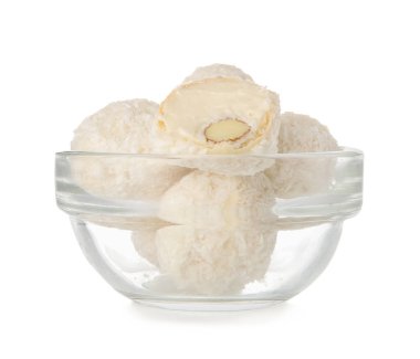 Beyaz arka planda izole edilmiş lezzetli hindistan cevizi şekerleriyle dolu cam kase.