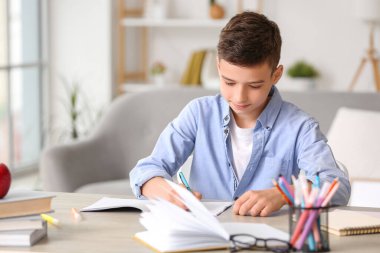 Küçük çocuk evde ders alıyor.