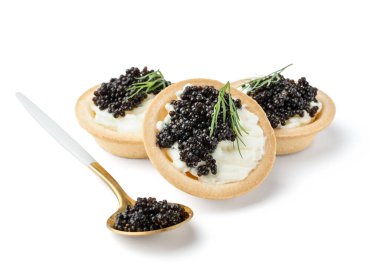 Tasty tartlets with black caviar on white background