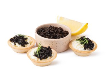 Tasty tartlets with black caviar on white background