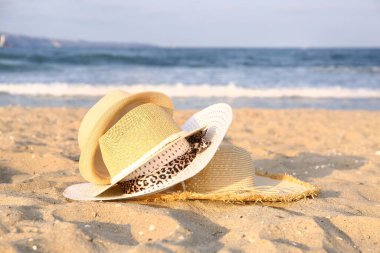 Denize yakın kumda saman şapkalar