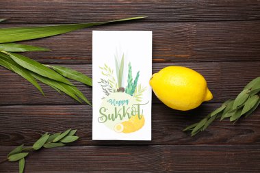 Dört tür (lulav, hadas, arava, etrog) ve kahverengi ahşap arka planda Mutlu SUKKOT yazılı tebrik kartı