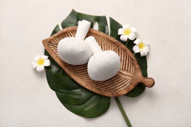 Beyaz arka planda bitki torbaları ve çiçekleri olan güzel bir spa kompozisyonu.