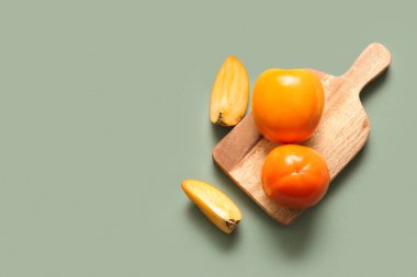 Tahta tahta, yeşil arka planda tatlı olgun hurmalar.