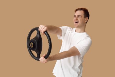 Bej arka planda direksiyonu olan genç bir adam.