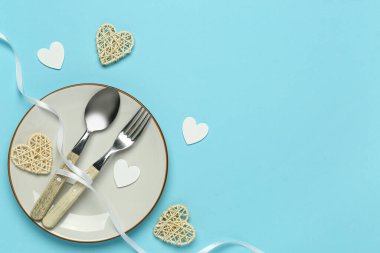 Mavi arka planda kurdeleli ve kalpleri olan güzel bir masa. Sevgililer Günü kutlaması