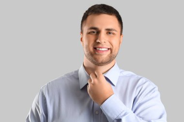 Gri arka planda gülümseyen yakışıklı iş adamı, yakın plan