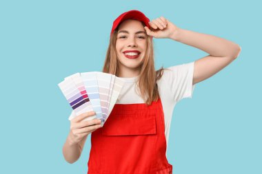 Mavi arka planda renk paletleri olan kadın ressam