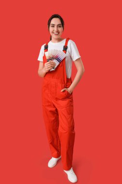 Kırmızı arkaplanda renk paletleri olan kadın ressam