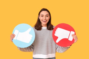 Sarı arka planda ikonlar olan ve sevmeyen güzel, genç, mutlu bir kadın.