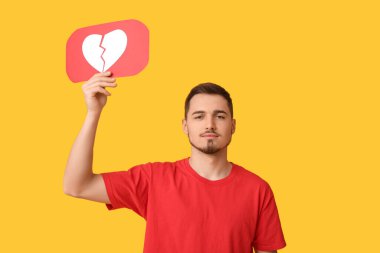 Sarı arka planda kalbi sevmeyen yakışıklı genç adam.