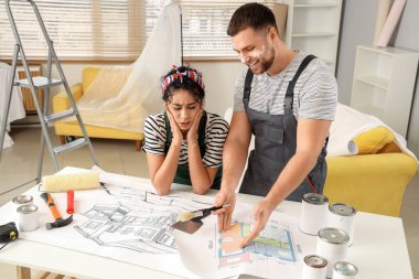 Güzel, genç ve düşünceli bir çift tamir sırasında yeni evlerinin tasarımını planlıyor.