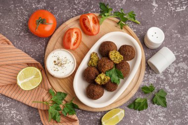 Nefis falafel köfteli, soslu ve domatesli bir tabak.