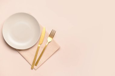 Pembe arka planda temiz tabak ve çatal bıçak takımı