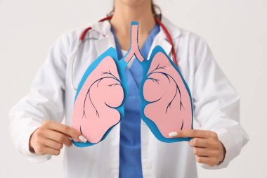 Beyaz arka planda kağıt ciğerli kadın doktor, yakın plan.