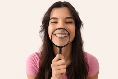 Gülümseyen genç kadın arka planda dişlerini büyütüyor, yakın plan.