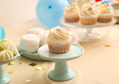 Bej masadaki doğum günü partisi için lezzetli beyaz kekle tatlı standı, yakın plan.