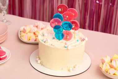 Pembe masadaki doğum günü partisi için şekerli pasta