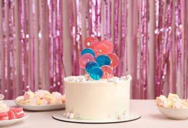 Doğum günü partisi için masada pembe süslemeli kek.