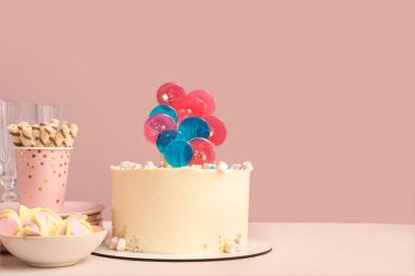 Doğum günü partisi için şekerli pasta pembe duvarın karşısında.