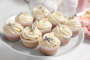 Doğum günü partisi için lezzetli beyaz kekleri olan tatlı standı masada, yakın plan.