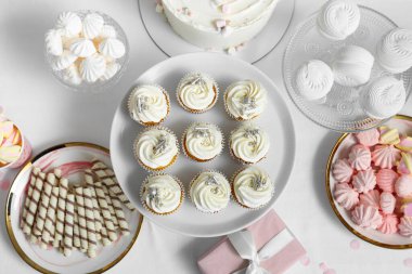 Tatlı standı, lezzetli beyaz kekler ve masadaki doğum günü partisi için diğer tatlılar.