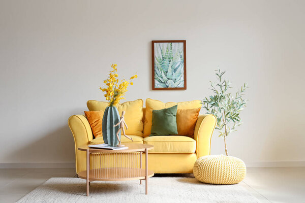 Interior of living room with sofa and artificial flowers on table