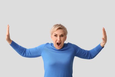 Hafif arka planda korkmuş olgun bir kadın