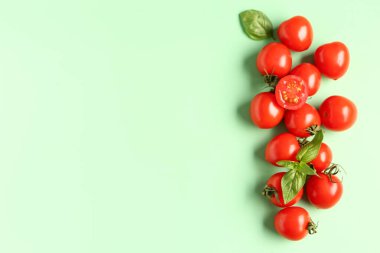 Yeşil arka planda taze vişneli domates ve fesleğen.