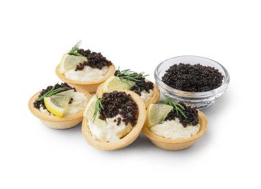 Tasty tartlets with black caviar on white background