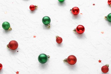 Beyaz arka planda Noel baloları ve konfeti