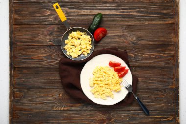 Ahşap zemin üzerinde lezzetli çırpılmış yumurta ve sebze kompozisyonu