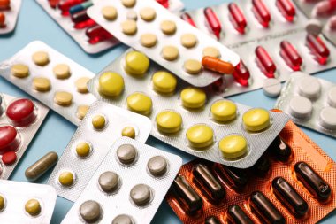 Mavi arka planda farklı haplar içeren kabarcık paketleri