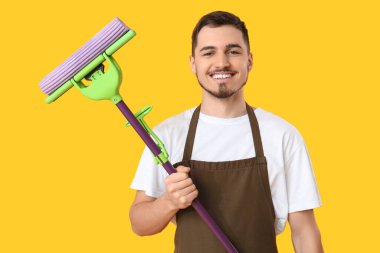 Sarı arka planda yer paspası olan erkek hademe