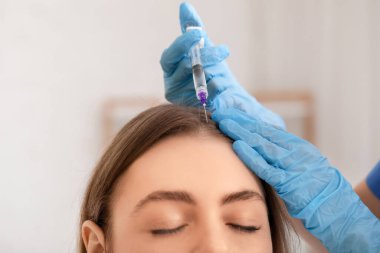 Genç bir kadın güzellik salonunda iğne oluyor, yakın çekim.