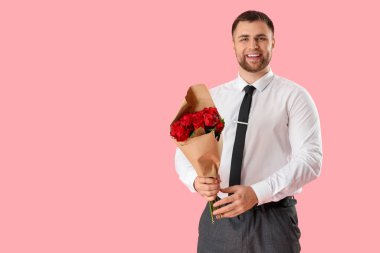 Pembe arka planda çiçekli yakışıklı bir adam.