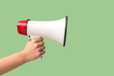 Yeşil arka planda megafonu olan bir kadın.