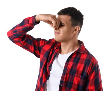 Beyaz arka plandaki kötü koku yüzünden burnunu çimdikleyen yakışıklı genç adam.