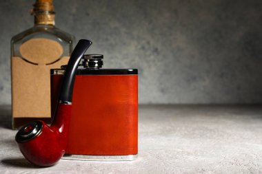 Yeni cep şişesi ve arka planda sigara piposu