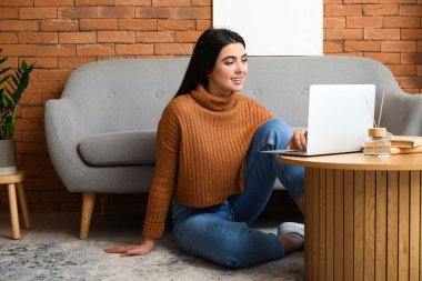 Evde dizüstü bilgisayarla çalışan serbest çalışan bir kadın.