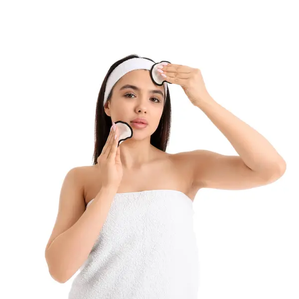 stock image Young woman removing makeup with cotton pads on white background