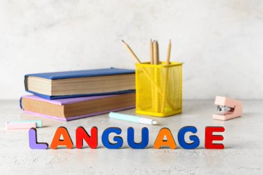 Kırtasiye ve kelime dili beyaz masadaki ahşap harflerden yapılmıştır.