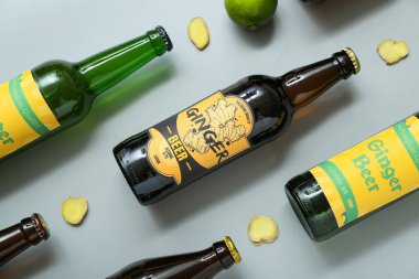 Gri arka planda farklı zencefilli bira ve limonlu kompozisyon