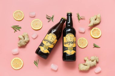 Taze zencefilli bira, biberiye, limon dilimleri ve pembe arka planda buz küpleriyle kompozisyon