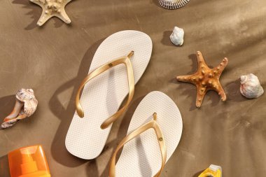 Grunge kahverengi arka planda güneş kremi sürmüş kadın tarzı terlikler.