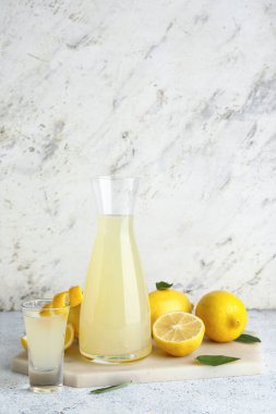 Şişe ve beyaz arka planda lezzetli limoncello.