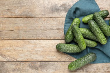 Ahşap arka planda bir yığın taze salatalık.